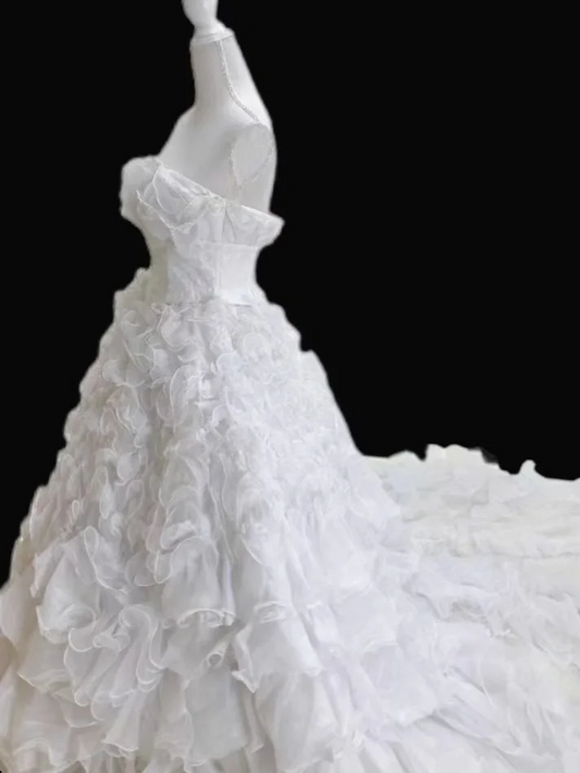 White strapless ball gown with a cinched waist and a voluminous tiered cake skirt; bridal gown R7300